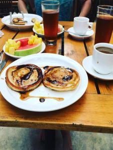 a table with a plate of pancakes and fruit and drinks at Green Sanctuary Hotel in Nosara