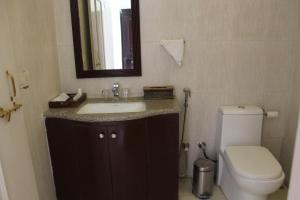 a bathroom with a sink and a toilet and a mirror at Sanchal Fort in Bārmer +18 photos