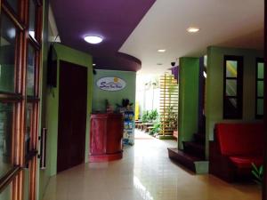 un couloir de magasins avec des murs verts et un plafond violet dans l'établissement Shore Time Hotel - Annex, à Boracay