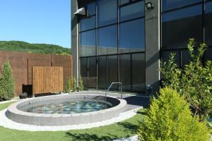 un bâtiment avec une piscine circulaire en face d'un bâtiment dans l'établissement Tokachi Nauman Onsen Hotel arco, à Makubetsu