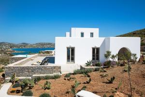 una casa bianca in cima a una collina con cactus di Natura Villas Paros a Molos Parou