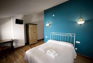 Un dormitorio con una cama con una pared azul. en Casa Rural Maialde, en Elgeta