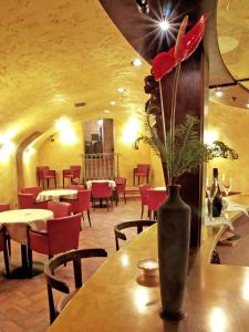 ボルノにあるAlbergo Venturelliのレストランのテーブル上に赤い花瓶