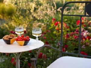 a table with two glasses of wine and a bowl of fruit at Agriturismo La Fattoria Del Boschetto in Fontanellato
