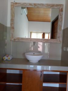 a bathroom with a sink and a mirror at Radya Homestay in Nusa Lembongan