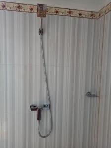 a shower in a bathroom with a shower curtain at Radya Homestay in Nusa Lembongan