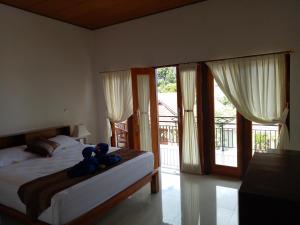 a bedroom with a bed with a teddy bear on it at Radya Homestay in Nusa Lembongan