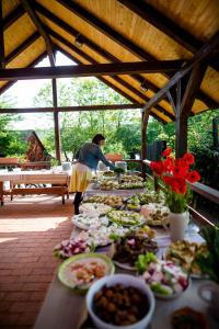 a woman standing in front of a table of food at Pension Bassen in Bazna