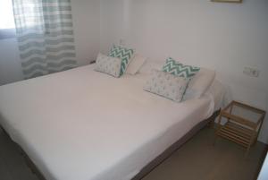 コニル・デ・ラ・フロンテーラにあるApartamento Tirma Conilの白いベッド(枕2つ付)