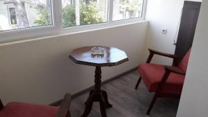 a small table in a room with two chairs and a window at Ureki GuestHouse in Ureki