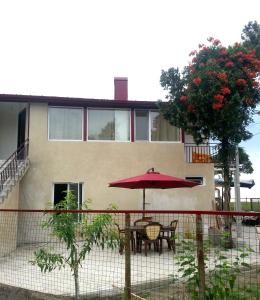 a red umbrella and table in front of a house at Ureki GuestHouse in Ureki