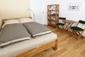 Bett in einem Zimmer mit Tisch und Stühlen in der Unterkunft Zur Hauptwache - Lenzen (Elbe) in Lenzen