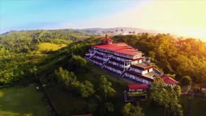 a large building with a red roof on a hill at Caliraya Resort Club in Lumban