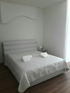 a white bed with two towels on top of it at Il sogno di Ele in Polignano a Mare