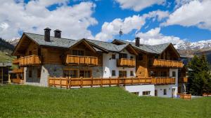 duży drewniany dom na szczycie wzgórza w obiekcie Chalet Bellavista w Livigno