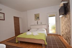 a bedroom with a bed with a green blanket at Apartment Smokrovic in Starigrad