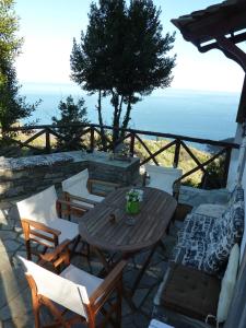 eine Terrasse mit einem Tisch, Stühlen und Meerblick in der Unterkunft Villa Thea in Makrirrákhi