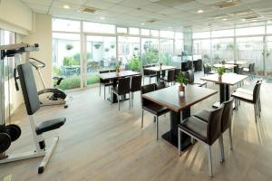 un restaurante con mesas, sillas y ventanas en Cambridge Hotel - Yung Kang en Yongkang