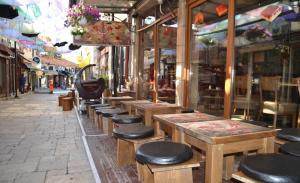 une rangée de tables et de tabourets devant un magasin dans l'établissement Hotel Ultra Star, à Skopje