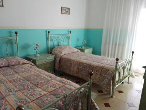 two beds in a bedroom with blue walls at B&B Lago Mulargia in Siùrgus Donigala