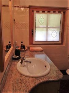 baño con lavabo y ventana en Maso Al Plan en Rabbi