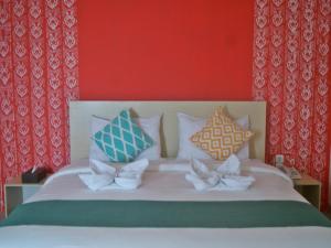 a bedroom with a bed with pillows on it at LEOS Hotel in Tomohon