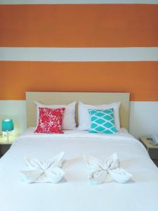 a white bed with two pillows on top of it at LEOS Hotel in Tomohon