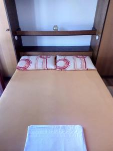 uma pequena cama com duas almofadas em cima em Apartment Zdravka em Blace
