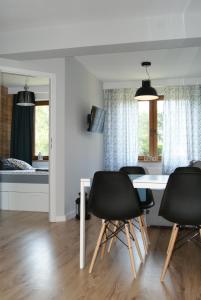 a dining room with a table and four chairs at Apartament Gratka in Dziwnówek