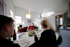a group of people sitting at a table eating food at Tangsø Hytteby in Bækmarksbro