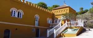a yellow building with a white staircase in front of it at Hostal La Parada in Bornos