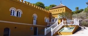 un edificio amarillo con una escalera blanca delante de él en Hostal La Parada, en Bornos