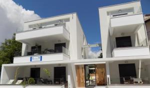 un edificio blanco con 2 balcones en Atlas Relax, en Kallithea Halkidikis