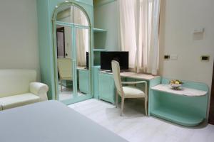 um quarto com uma secretária, um computador e um espelho. em Hotel Europa em Foggia