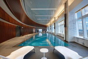 a swimming pool in a building with two benches at Signiel Seoul in Seoul