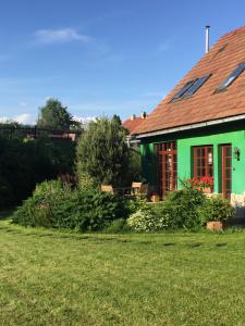 una casa verde con un jardín delante de ella en Penzión u Maroša, en Kežmarok