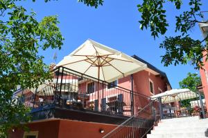 a balcony with an umbrella on a building at Casa Vacanze La Stele in Castelmonte