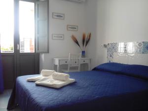 カステッランマーレ・デル・ゴルフォにあるNonna Giò Houseのベッドルーム1室(ブルーベッド1台、タオル付)