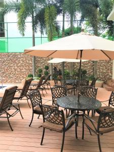 una mesa y sillas con una sombrilla en el patio en Savannah Resort Hotel en Ángeles