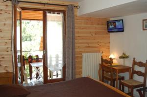 a bedroom with a bed and a table and a balcony at Au Bon Logis in Risoul