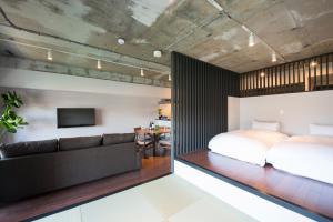 a bedroom with a bed and a couch at A Good Day Fukuoka Riverside in Fukuoka