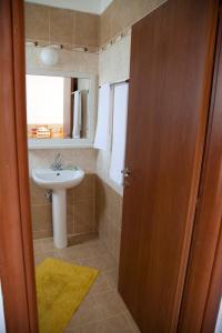 a bathroom with a sink and a toilet and a mirror at Kochylari Apartments in Kefalos