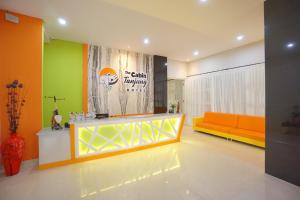 a living room with an orange couch and a table at The Cabin Tanjung Hotel Wonosobo in Wonosobo