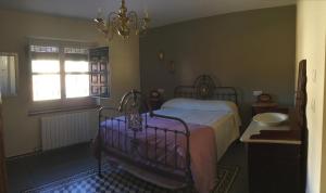 een slaapkamer met een bed, een raam en een kroonluchter bij Finca La Florida De San Antonio in Huércal-Overa