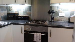 a kitchen with a stove and a counter top at Stonehouse Apartment in Mexborough