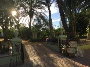 een poort in een park met palmbomen op de achtergrond bij Finca La Florida De San Antonio in Huércal-Overa