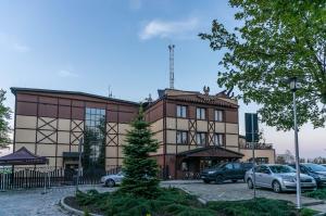 a building with cars parked in front of it at Resort Strzelnica in Kochcice