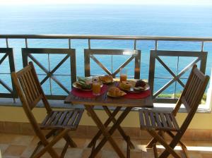 uma mesa com um prato de comida numa varanda em Oceanfront Apartment no Funchal
