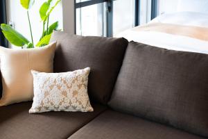 a bunch of pillows sitting on a couch at A Good Day Fukuoka Riverside in Fukuoka