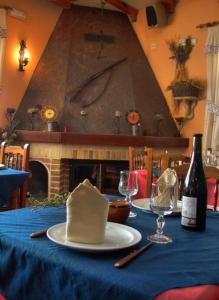 a table with a bottle of wine and a hat on it at Complejo Rural Agoga de Las Médulas in Las Médulas